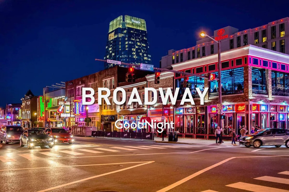 A vibrant street scene on Broadway at night, featuring neon lights, busy foot traffic, high-rise buildings, and people enjoying the energetic nightlife of Nashville. The image captures the essence of live music venues and the dynamic atmosphere that draws visitors to the city.