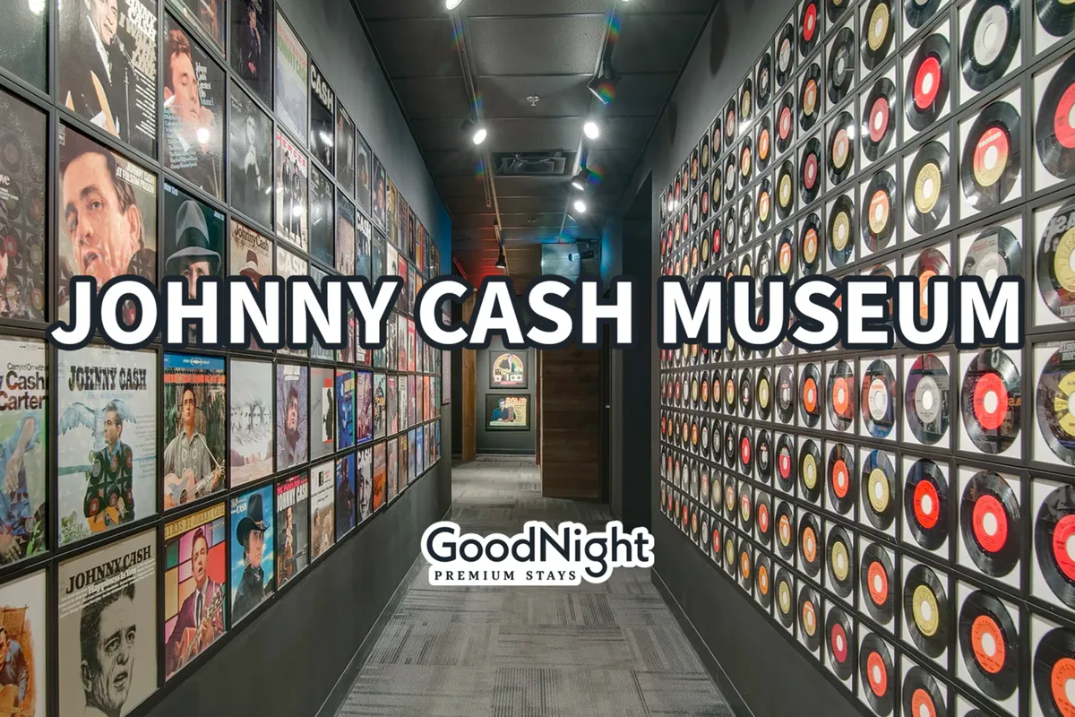 An interior view of the Johnny Cash Museum, with walls adorned with album covers and vinyl records, illuminated display areas, and a nostalgic atmosphere. Visitors are seen exploring music history and engaging with the exhibits.
